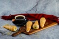 Cream Roll or cream buns served on wooden board with cup of black coffee on napkin side view of french breakfast baked