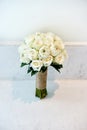 Cream roses wedding bouquet of the bride n the white wall Royalty Free Stock Photo