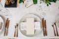 Wedding dinner table reception. The cream sheet of the menu is in a plate with a cloth napkin. Cutlery laid out