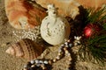 Cream snowman decoration on beach sand rock backdrop shell natural african beads red ball Christmas in July