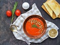 Cream soup of baked sweet pepper and tomato in a clay bowl on a brown concrete background. Served with dried white bread and Royalty Free Stock Photo