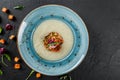 Cream soup of celery with tartare from baked vegetables decorated from croutons and arugula in plate on dark stone background Royalty Free Stock Photo