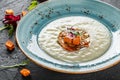 Cream soup of celery with tartare from baked vegetables decorated from croutons and arugula in plate on dark stone background Royalty Free Stock Photo