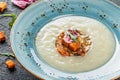 Cream soup of celery with tartare from baked vegetables decorated from croutons and arugula in plate on dark stone background Royalty Free Stock Photo