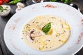 Cream soup with mushrooms, herbs, cheese parmesan, basil, sesame on plate on dark wooden background. Royalty Free Stock Photo