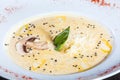 Cream soup with mushrooms, herbs, cheese parmesan, basil, sesame on plate on dark wooden background Royalty Free Stock Photo