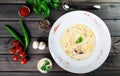 Cream soup with mushrooms, herbs, cheese parmesan, basil, sesame on plate on dark wooden background. Royalty Free Stock Photo