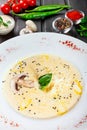 Cream soup with mushrooms, herbs, cheese parmesan, basil, sesame on plate on dark wooden background Royalty Free Stock Photo