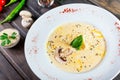 Cream soup with mushrooms, herbs, cheese parmesan, basil, sesame on plate on dark wooden background Royalty Free Stock Photo