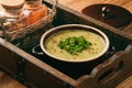Cream soup with potatoes, leek and peas on wooden table. Royalty Free Stock Photo