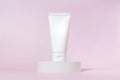 Cream tube with cream branding concept on cocncrete podium on pink background. Cosmetic skincare product blank plastic package.