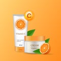 Cream with vitamin C in a glossy tube next to sliced oranges and leaves.