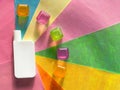 Cream bottle on a multicolour background. Transparent cubes with colored shadows