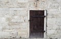 Cream and white old brick limestone texture background home wall with old dark wooden door. Back flat stone granite Royalty Free Stock Photo