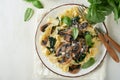 Creamy Alfredo pasta. Italian pasta fettuccini with mushrooms, chicken meat, spinach, basil and cream sauce on white stone Royalty Free Stock Photo