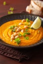 Creamy carrot chickpea soup on dark rustic background