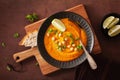 Creamy carrot chickpea soup on dark rustic background