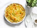 Creamy chicken, cauliflower, leek pie with crispy potato cheese topping on light background, top view. Comfort food Royalty Free Stock Photo