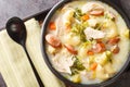 Creamy Chicken Sopas is a Filipino soup with pasta, vegetables, sausages and chicken close-up in a bowl. Horizontal top view