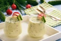 Creamy cold yogurt soup with vegetables served in glasses.