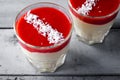 Creamy dessert with strawberry sauce and coconut flakes in glasses Royalty Free Stock Photo