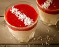 Creamy dessert with strawberry sauce and coconut flakes in glasses Royalty Free Stock Photo