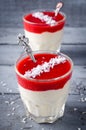 Creamy dessert with strawberry sauce and coconut flakes in glasses Royalty Free Stock Photo