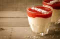 Creamy dessert with strawberry sauce and coconut flakes in glasses Royalty Free Stock Photo