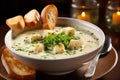 Creamy garlic soup garnished with crunchy croutons and fresh chives in a white bowl