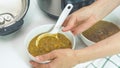 Creamy lentil soup cooked in multi cooker close up in a bowl, woman hands Royalty Free Stock Photo