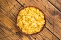 Creamy mac and cheese in a rustic bowl on a wooden table, garnished with fresh thyme, Royalty Free Stock Photo