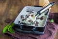 Creamy mint ice cream with chocolate chips in a black ceramic mold on a brown wooden background. Ice cream recipes