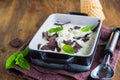 Creamy mint ice cream with chocolate chips in a black ceramic mold on a brown wooden background. Ice cream recipes