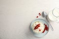 Creamy rice pudding with red currant in bowl served on white wooden table, top view. Royalty Free Stock Photo