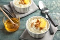 Creamy rice pudding with walnuts and orange slices in ramekins served