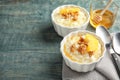 Creamy rice pudding with walnuts and orange slices in ramekins served on wooden table