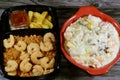 A creamy seafood casserole pot shrimps, squid calamari, fish fillet, mozzarella cheese, colored bell pepper slices and white