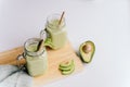 creamy smoothie from avocado and banana in glass cups with paper tubes on a light background. no plastic. Royalty Free Stock Photo