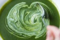 Creamy spinach soup in plate beeing mixed with spoon Royalty Free Stock Photo