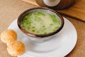 Creamy vegetable soup served with cheese bread. Pureed celery soup with green pea in a bowl close-up on rustic background Royalty Free Stock Photo