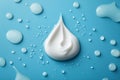 Creamy White Droplet on Blue Surface Surrounded by Small Water Drops and Blobs Royalty Free Stock Photo
