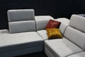 Creamy white leather luxury couch with two golden decorative pillows on dark background, as displayed by Bospol company