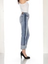 Crease & Clips Slim Women`s Light Blue Jeans, Woman in Blue tight jeans with white heels, white background