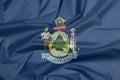 Crease of Maine fabric flag background. Maine coat of arms defacing blue field Royalty Free Stock Photo