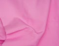 Creased pink gabardine. Rumpled texture.Folded fabric