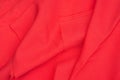 Creased red gabardine. Rumpled texture. Folded fabric