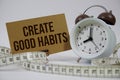 Create Good Habits text with alarm clock and measure tape on white background Royalty Free Stock Photo