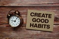Create Good Habits text with alarm clock on wooden background Royalty Free Stock Photo