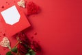 Overhead view of rattan hearts, red roses, a love letter, sweet sprinkles, and red background