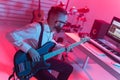 Create music and a recording studio concept - Bearded funny man guitarist recording electric bass guitar track in home